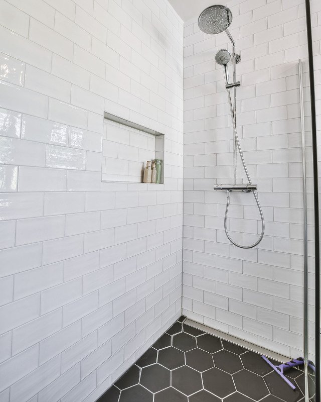 A bathroom adorned with exquisite mosaic tiles and a glass shower door, showcasing the tile upgrade expertise of Hoboken Bathroom Renovation in Hoboken, NJ.