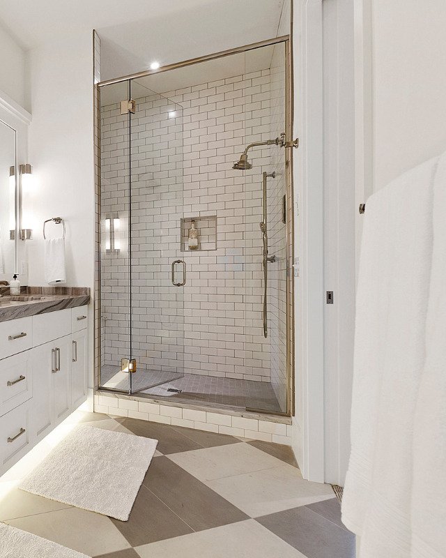 Elegant bathroom renovation in Hoboken featuring a warm color tile floor and glass enclosed shower.