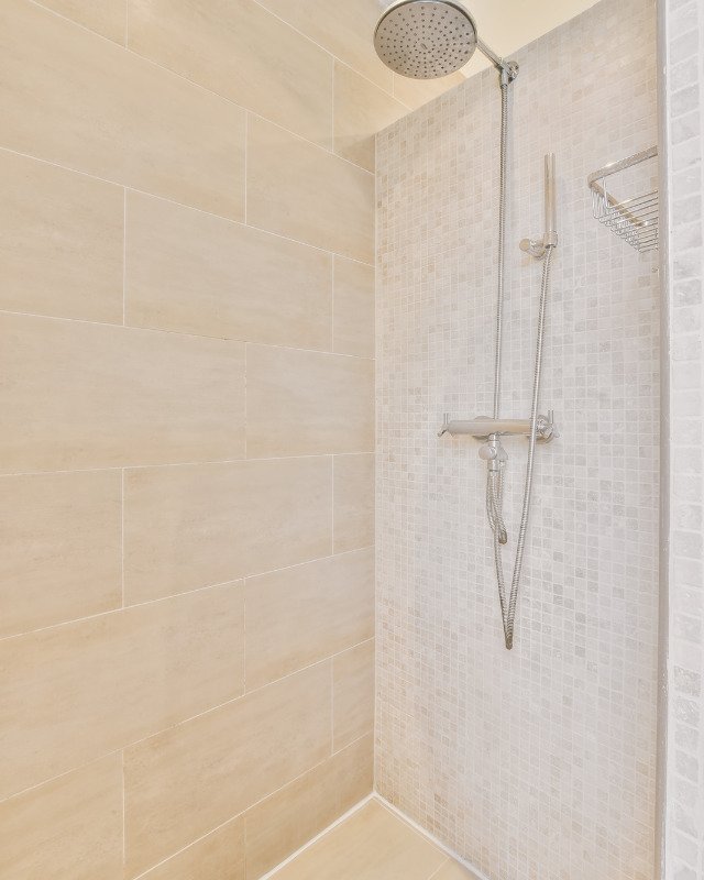A Jersey City, NJ shower renovation featuring warm color tiles.